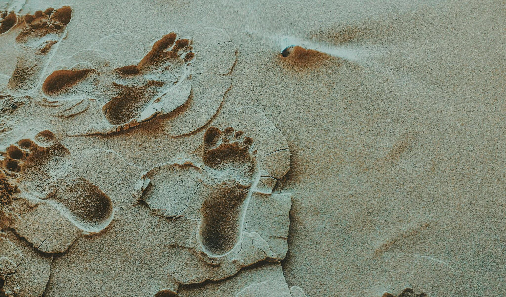 Voetafdrukken in het zand op het strand in België van persoon met platvoet, patiënt van Foot Care Center by Spronken Orthopedie