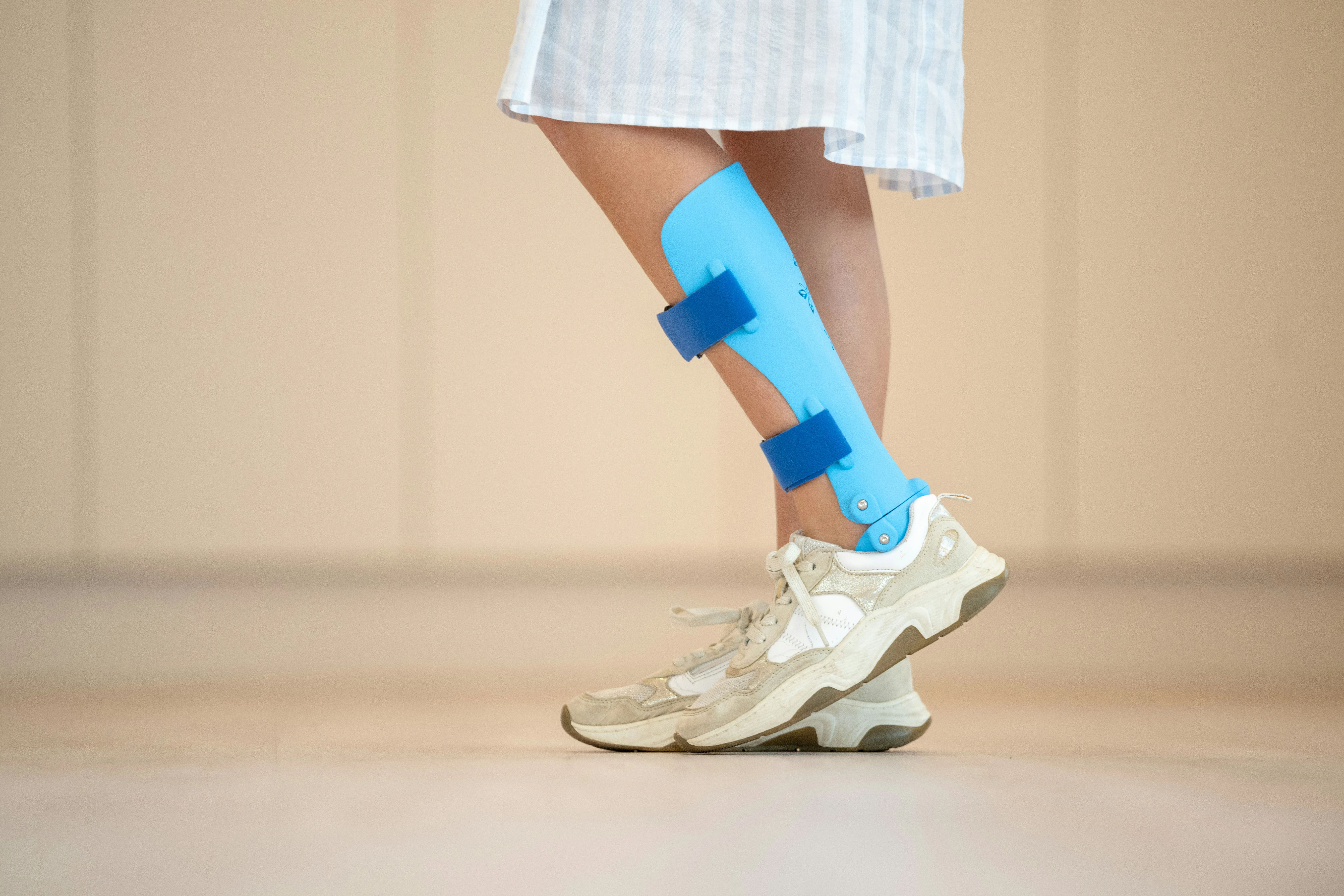 Vrouw met beenorthese van Foot Care Center by Spronken orthopedie wandelt