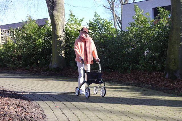 Vrouw met rollator wandelend op revalidatieschoenen van Foot Care Center by Spronken Orthopedie